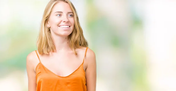 美丽的年轻女子穿着橙色衬衫在孤立的背景看着一边面带微笑 自然的表情 笑自信 — 图库照片