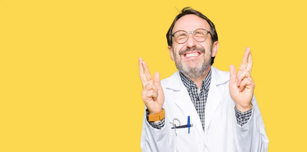 Médicos Mediana Edad Con Abrigo Médico Sonriendo Cruzando Los Dedos — Foto de Stock