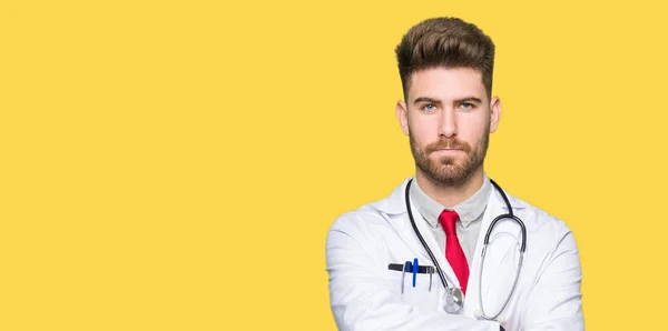 若いハンサムな医者組んだ腕で顔に医療コート懐疑論者と神経 不賛成の式を着た男 否定的な人 — ストック写真