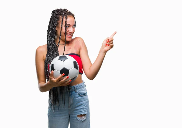 年轻编织头发非洲裔美国人与出生标记举行足球在孤立的背景非常高兴地指向身边的手和手指 — 图库照片