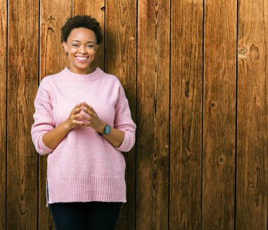 İzole arka plan el ele tutusun güzel genç Afrikalı-Amerikalı kadın ve rahat ve neşeli gülümseyen parmak çarpı işareti. Başarı ve iyimser