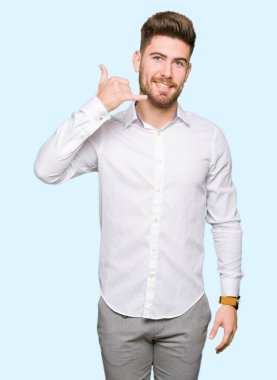 Genç yakışıklı iş adamı yapıyor gülümseyen telefon hareketi ile el ve parmak telefonda konuşuyor gibi. Kavramları iletişim.