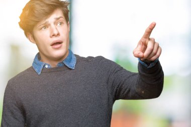 Genç yakışıklı zarif adam izole arka plan ile sürpriz devam et, parmakla üzerinde açık ağız ifade, önünde bir şey hayret