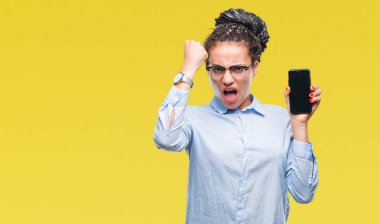 Genç örgülü saç Afro-Amerikan iş kız gösteren ekran smartphone üzerinde izole arka rahatsız ve boşa çıkarmak ile öfke, çılgın ve yükseltilmiş eliyle diye bağıran öfke kavramı bağırarak.