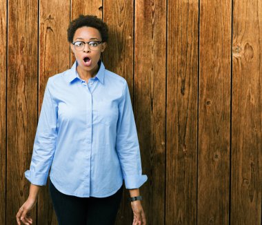 Genç güzel Afro-Amerikan iş kadını izole arka plan korkuyor ve şok sürpriz ifade, korku ve heyecan yüz üzerinden.