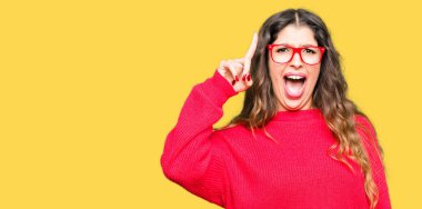 Kırmızı giyen genç güzel kadın başarılı fikirle işaret parmağı gözlük. Çıktıktan ve mutlu. Bir numara.