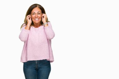 Yüksek sesle müzik gürültü rahatsız ifade parmaklarıyla kulaklarıyla kapsayan izole arka plan üzerinde kış kazak giyen güzel orta yaş yetişkin kadın. Sağır kavramı.