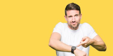 Yakışıklı adam acele işaretleme izlemek için zaman, sabırsızlık, üzgün ve kızgın son tarih gecikme için rahat beyaz t-shirt giyen