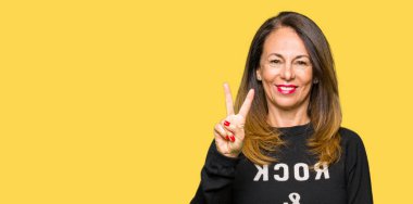 Güzel Orta Çağ kadın taş ve rulo kazak gösteren ve parmaklar iki numarası ile işaret giyiyor iken güven ve mutlu gülümseyen.