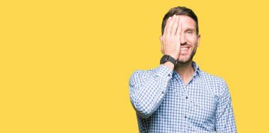 El yüz ve sürpriz duygu kendinden emin gülümseme ile tek gözüyle kapsayan mavi gözlü yakışıklı iş adamı.