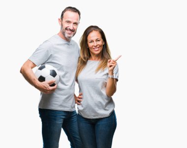 Orta yaş İspanyol çift futbol futbol topu izole arka plan üzerinde çok mutlu el ve parmak ile tarafına işaret tutan