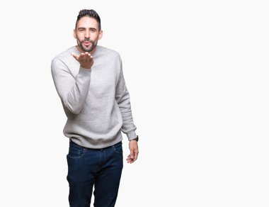 Bir öpücük el ile güzel ve seksi olmak hava üfleme kamera bakarak izole arka plan üzerinde sweatshirt giyen genç yakışıklı adam. Aşk ifade.