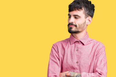 Yakışıklı delikanlı tarafına silahlarla seyir gülümseyen izole arka plan üzerinde pembe gömlek giymiş ikna ve kendine güvenen geçti