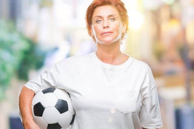Acımak yüz ciddi düşünüyorum üstünde kendine güvenen bir ifade ile izole arka plan üzerinde futbol topu tutan Atrractive üst düzey beyaz Kızıl saçlı kadın