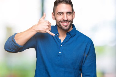 Yakışıklı delikanlı yapıyor gülümseyen izole arka plan üzerinde telefon hareketi ile el ve parmak telefonda konuşuyor gibi. Kavramları iletişim.