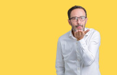 Bir öpücük el ile güzel ve seksi olmak hava üfleme kamera bakarak izole arka plan üzerinde gözlük takan yakışıklı orta yaş zarif üst düzey iş adamı. Aşk ifade.