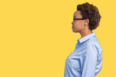 Genç güzel Afro-Amerikan iş kadını izole arka tarafına, seyir üzerinde dinlenmek doğal yüz emin gülümseme ile pozuyla profil.