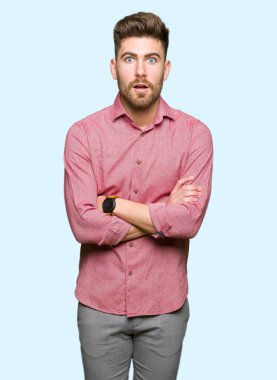 Genç yakışıklı iş casual adam korkuyor ve sürpriz ifade, korku ve heyecan yüz ile şok.