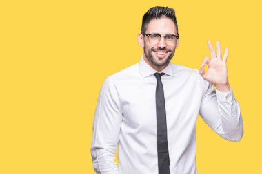 Genç yakışıklı iş adamı izole arka plan el ve parmaklar ok işaretiyle yapıyor olumlu gülümseyen üzerinde gözlük takıyorum. Başarılı ifade.