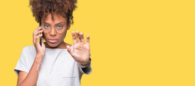 Genç Afro-Amerikan kadın Smartphone ile izole arka plan üzerinde söz açmak el dur işareti ile ciddi ve kendine güvenen ifade, savunma hareketi yapıyor