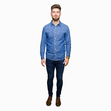 Komik surat ile yanakları şişirme rahat kot gömlek giymiş genç yakışıklı sarışın adam. Ağız ile hava, deli ifade şişirilmiş.