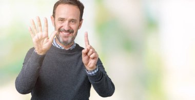 Yakışıklı orta yaş kıdemli adam izole arka planda gösteren bir kazak giyiyor ve parmak numarası altı ile işaret kadar emin ve mutlu gülümseyen.