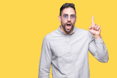 Genç yakışıklı adam başarılı fikirle izole arka plan işaret parmağı üzerinde güneş gözlüğü takıyor. Çıktıktan ve mutlu. Bir numara.