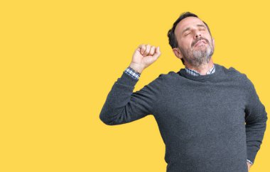 Geri, germe izole arka plan üzerinde bir kazak giyen yakışıklı orta yaş üst düzey adam yorgun ve rahat, uykulu ve erken sabah esneme