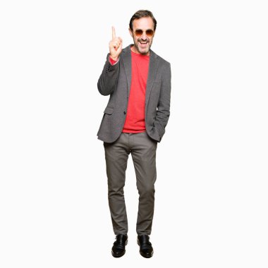 Orta yaş yakışıklı iş adamı ile başarılı fikir parmak işaret güneş gözlüğü takıyor. Çıktıktan ve mutlu. Bir numara.