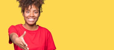 Güzel genç Afro-Amerikan kadın dostu sunan el sıkışma tebrik ve davet edici olarak gülümseyen izole arka plan yüzünden. Başarılı iş.