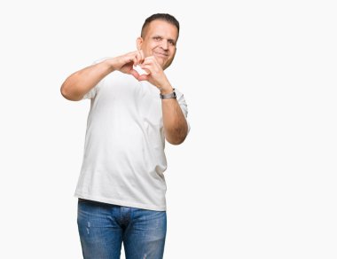 Orta yaş Arap adam wearig beyaz t-shirt üzerine arka plan aşık kalp simgesi ve elleriyle şekil gösteren gülümseyen izole. Romantik kavramı.
