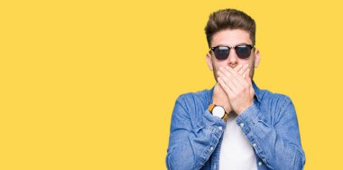 Denim ceket ağız hata için elleriyle kapsayan şok giyen genç yakışıklı zarif adam. Gizli kavramı.