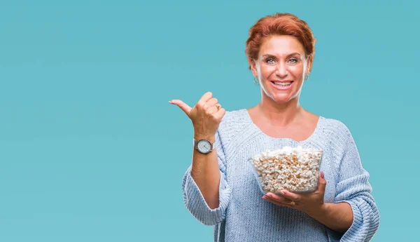 Korzystna Starszy Rude Kaukaski Kobieta Jedzenie Popcorn Białym Tle Wskazując — Zdjęcie stockowe