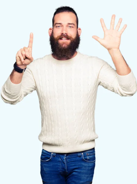 冬のセーター表示と指で上向きを身に着けている流行に敏感な若い男ナンバー 自信を持って 幸せな笑みを浮かべて — ストック写真