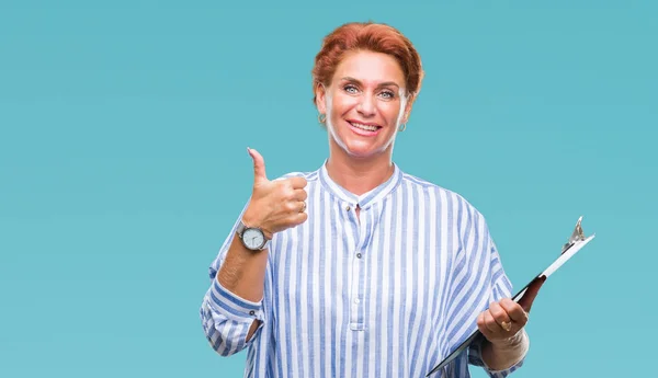 クリップボードに保持しているシニア白人女性が笑顔の サイン 優秀な兆候を親指をやって幸せの背景を分離 — ストック写真