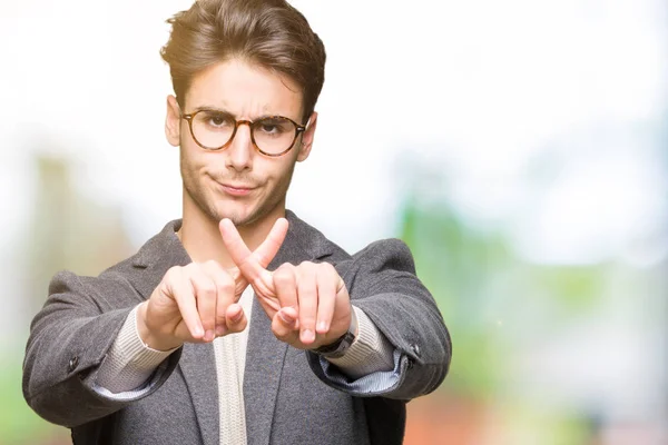 年轻的商人戴眼镜在孤立的背景拒绝表达交叉手指做消极的标志 — 图库照片