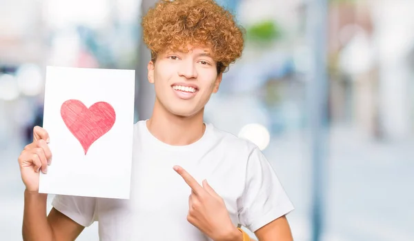 Joven Hombre Guapo Sosteniendo Papel Con Corazón Rojo Muy Feliz — Foto de Stock