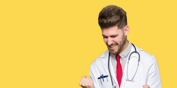 医療を着た若いハンサムな医者男コート非常に幸せと興奮の腕調達して勝者ジェスチャーをやって 笑みを浮かべて 成功のために叫んでいます お祝いのコンセプト — ストック写真