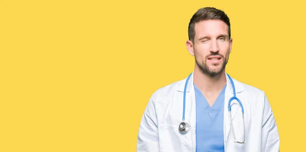 Guapo Doctor Hombre Vistiendo Uniforme Médico Sobre Fondo Aislado Guiño —  Fotos de Stock