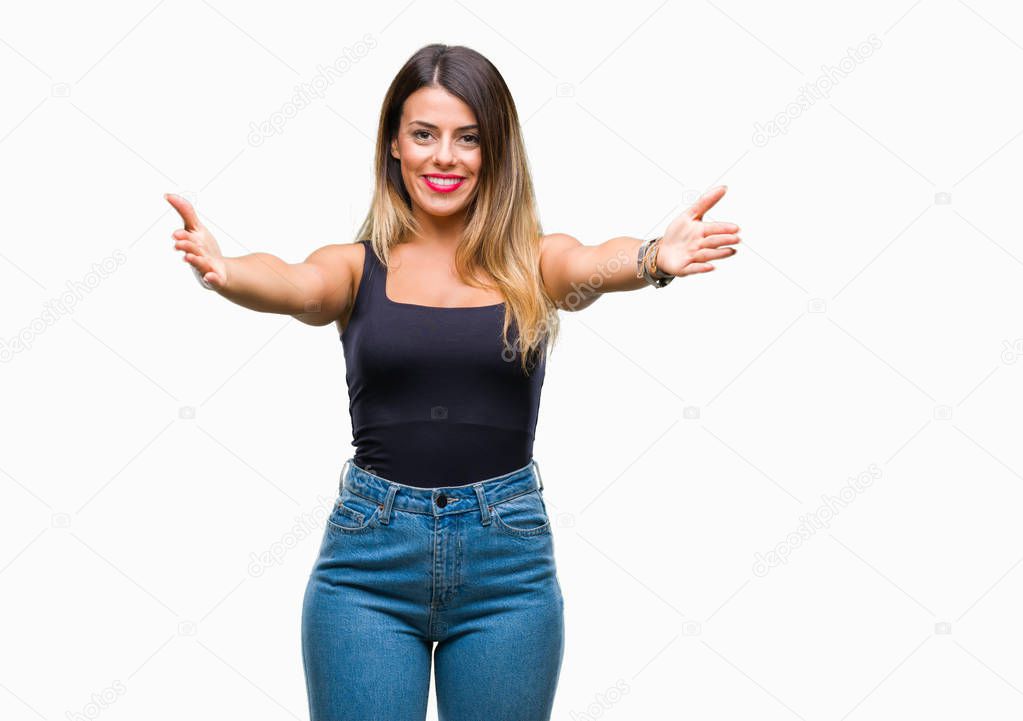 Young beautiful woman over isolated background looking at the camera smiling with open arms for hug. Cheerful expression embracing happiness.