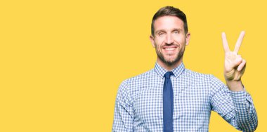 Yakışıklı iş adamı giyen kravat gösterme ve parmak ikinci ile gülümseyen ise kendinden emin ve mutlu yukarı dönük.