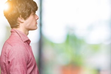 Genç yakışıklı iş adamı izole arka tarafına, seyir üzerinde dinlenmek doğal yüz emin gülümseme ile pozuyla profili.