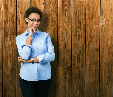 Genç güzel Afro-Amerikan iş kadın izole arka plan emin çapraz kollar ve çeneme kaldırdı el ile gülümseme ile kameraya bakıyor. Pozitif düşünce.