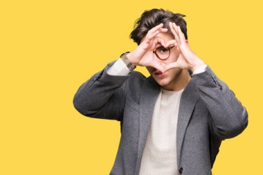 İzole arka plan yaparken kalp şekli el ve parmak işareti seyir gülümseyen ile üzerinde gözlük takan genç iş adamı