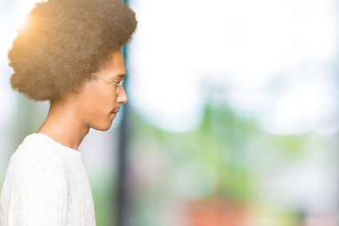 Afro saçlı tarafına, seyir gözlüklü genç Afro-Amerikan adam sakin ol kendine güvenen gülümseme ile doğal yüz pozuyla profili.