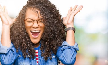 Kızgın ve silah ile başarı için deli kutluyor gözlük takıyorsun kıvırcık saçlı Genç güzel bir kadınla kaldırdı ve heyecanlı çığlık gözler kapalı. Kazanan kavramı