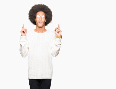 Afro saçlı gözlüklü genç Afro-Amerikan adam hayret ve yukarıya bakıyor ve parmakları ile işaret ve silah kaldırdı şaşırttı.