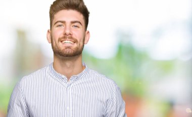 Eller birlikte genç yakışıklı adam ve rahat ve neşeli gülümseyen parmak çarpı işareti. Başarı ve iyimser