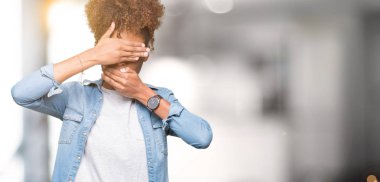 Güzel genç Afro-Amerikan kadın izole arka plan kaplaması gözler ve ağız el ile üzerinden gözlük takan şaşırttı ve şok. Duygu gizleme