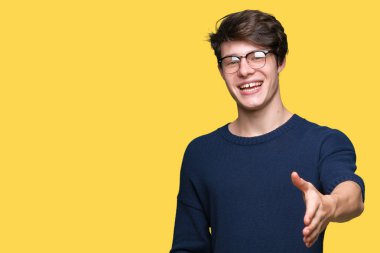 Tebrik ve davet edici dostu sunan karşılıklı gülümseyen izole arka plan üzerinde gözlük takan yakışıklı delikanlı. Başarılı iş.